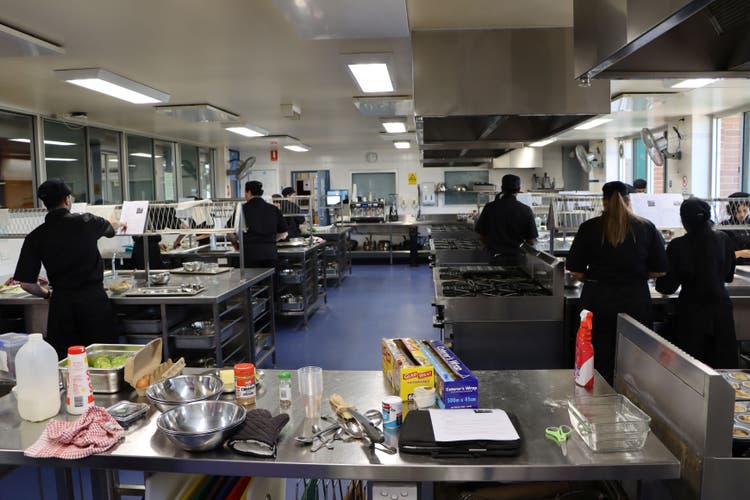 Hospitality students cooking in a commercial kitchen