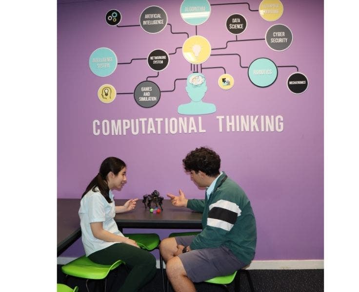 Two students discussing the capabilities of a robot.