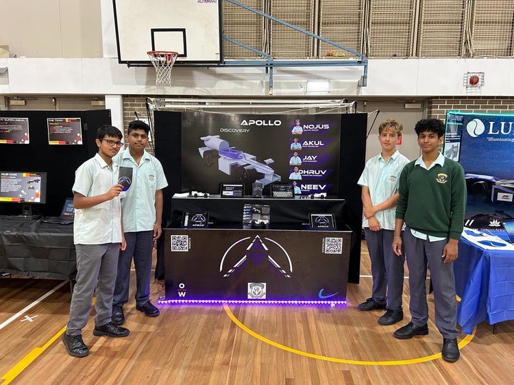 Our F1 in Schools team standing in front of their car display at the regional finals.